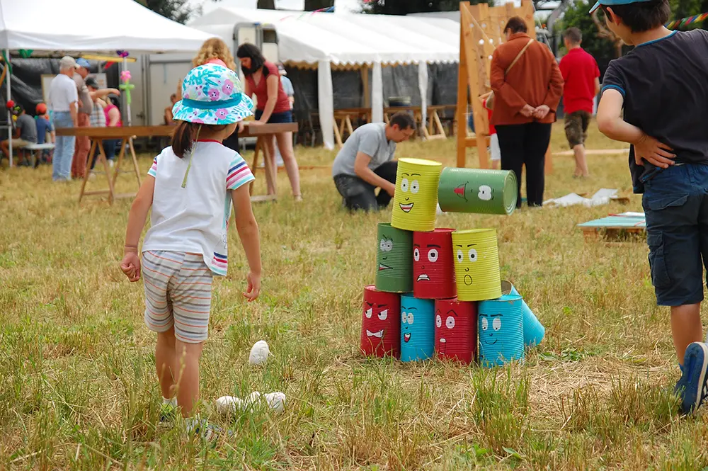 Un enfant fait tomber des boites empilés en jouant au festival au pré du son