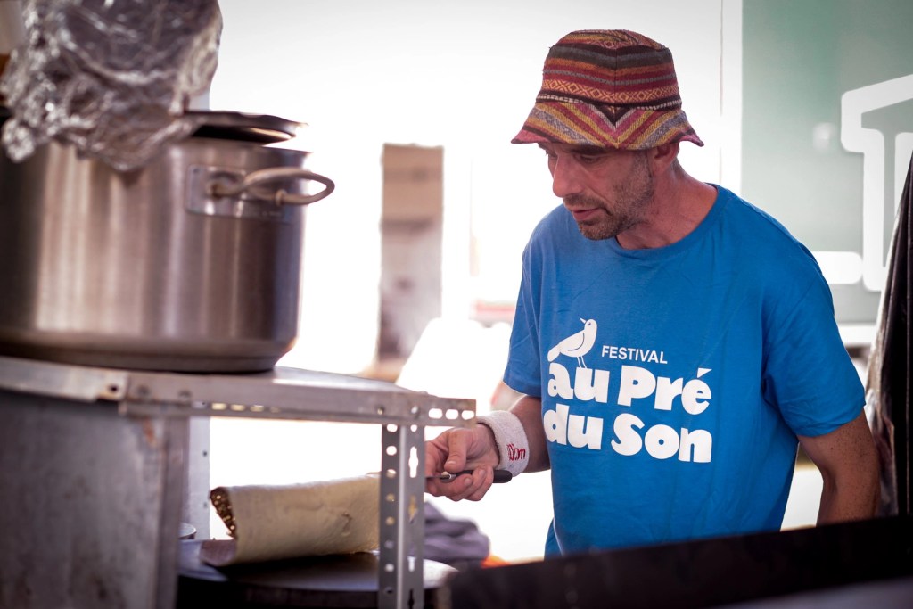 Un festivalier cuit des crepes au festival au pré du son