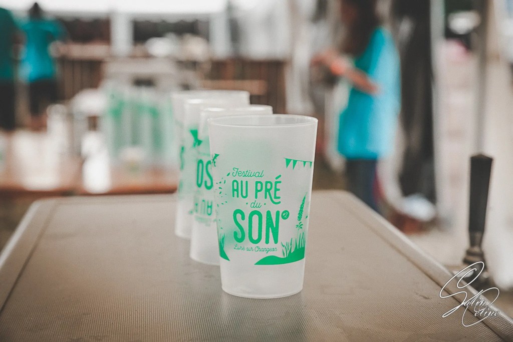 Des gobelets consignés de festival sont posés sur le bar au pré du son