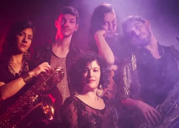 Le groupe de musique Hip hop hop crew pose avec leurs instruments sur un fond violet